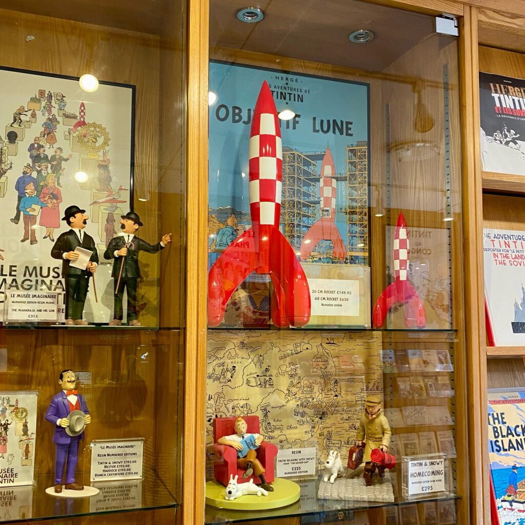 Display case featuring Tintin figurines and a red rocket model from the Adventures of Tintin series.