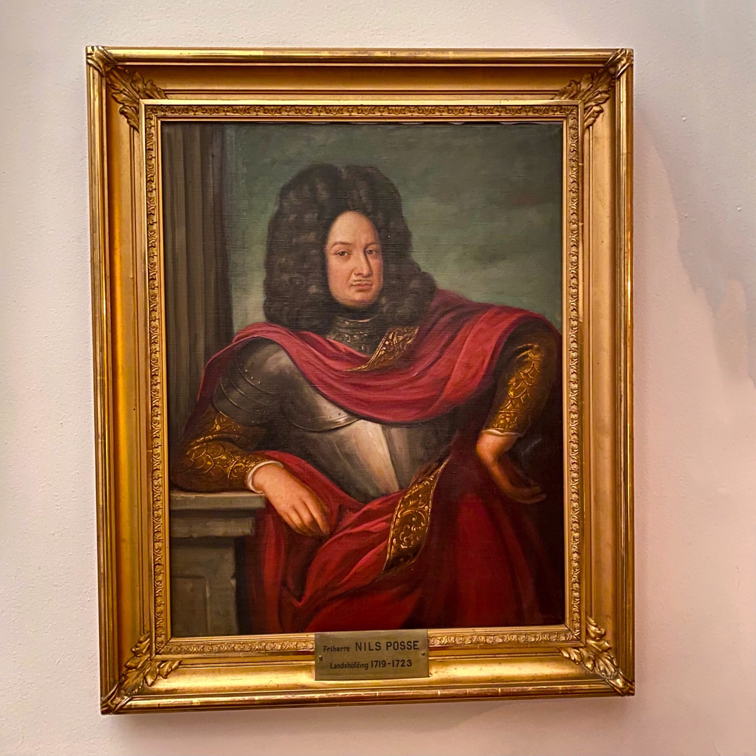 Portrait of Nils Posse, a gentleman in historical attire, featuring a red cloak and ornate armour.