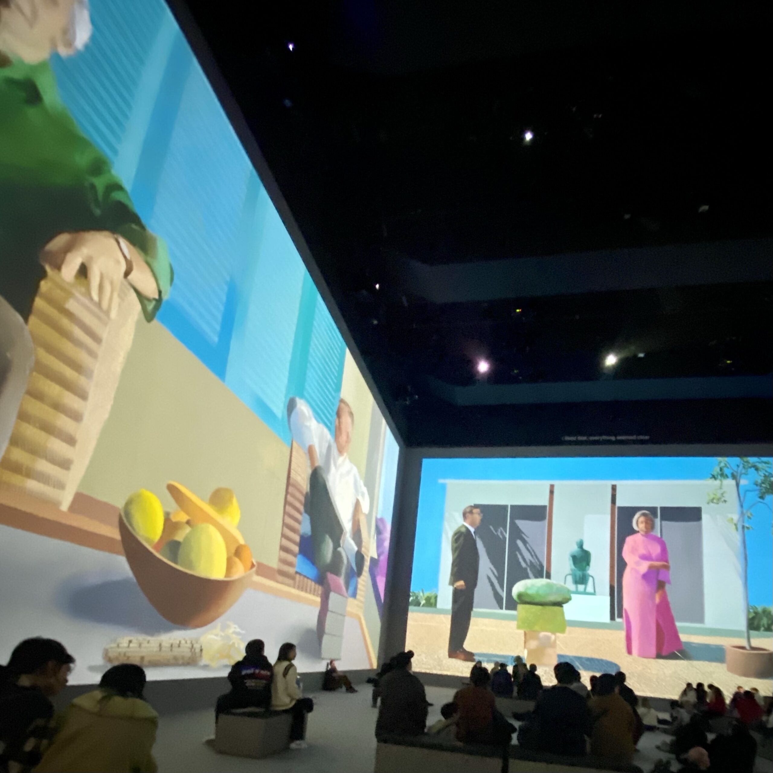 Large-scale projection of animated characters in a gallery setting, showcasing vibrant colours and artistic scenes.