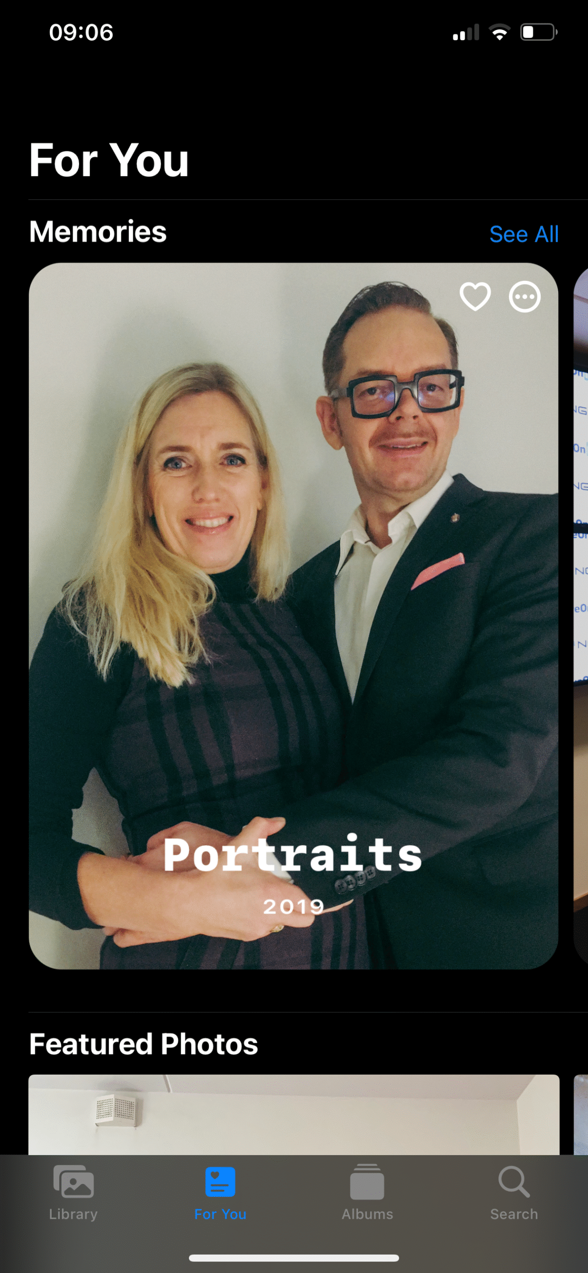 A man and a woman posing together, both smiling and dressed in formal attire.