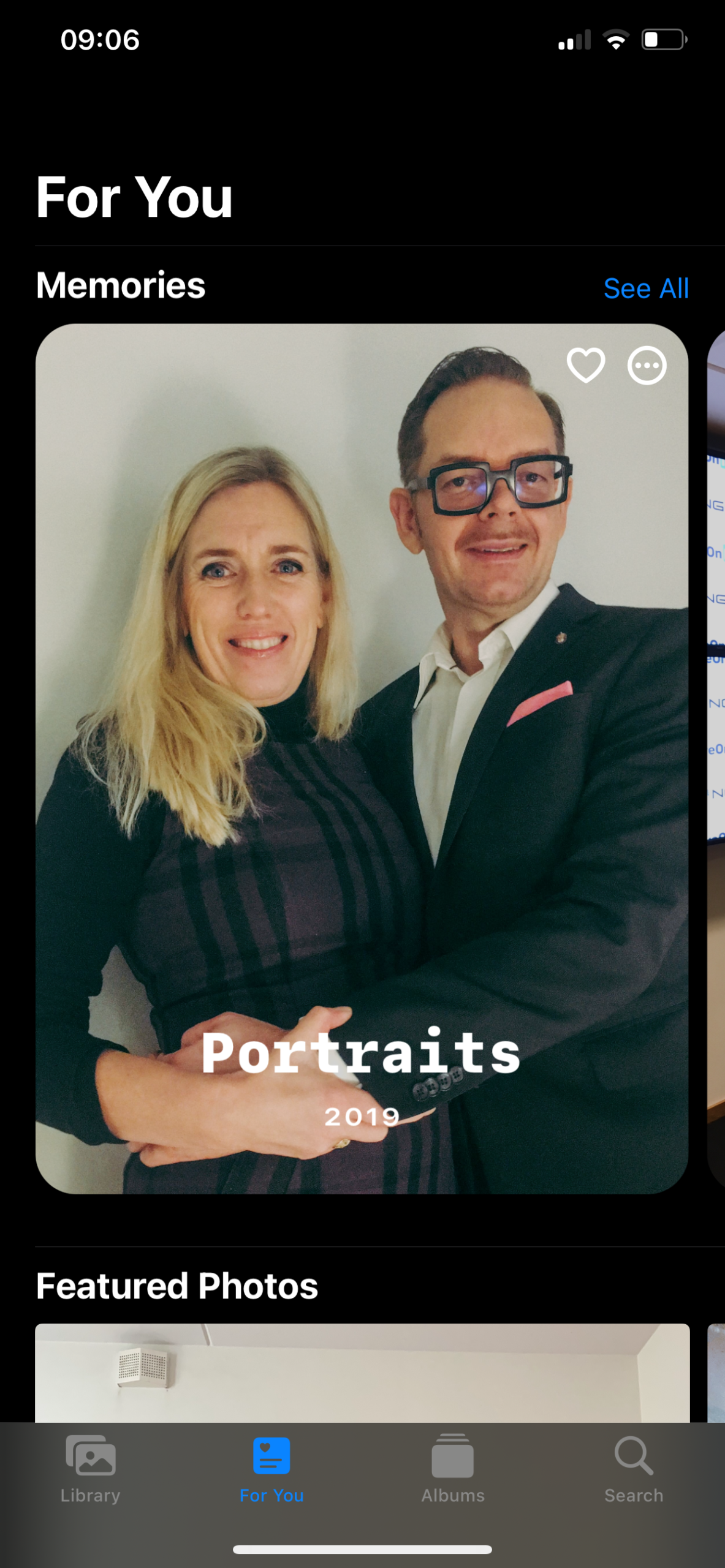 A man and a woman posing together, both smiling and dressed in formal attire.