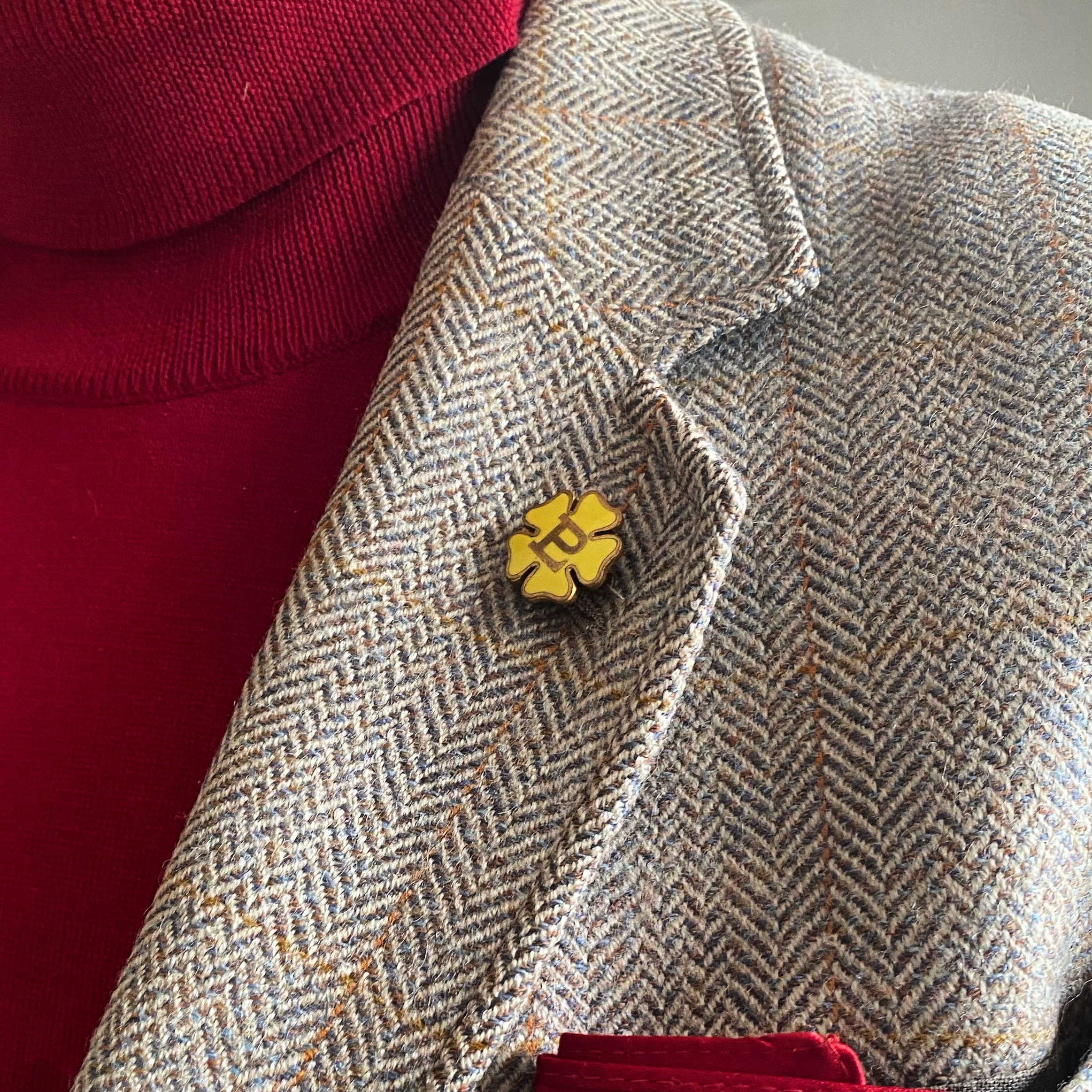 A 20th-century Primrose League badge displayed on a tweed jacket lapel.