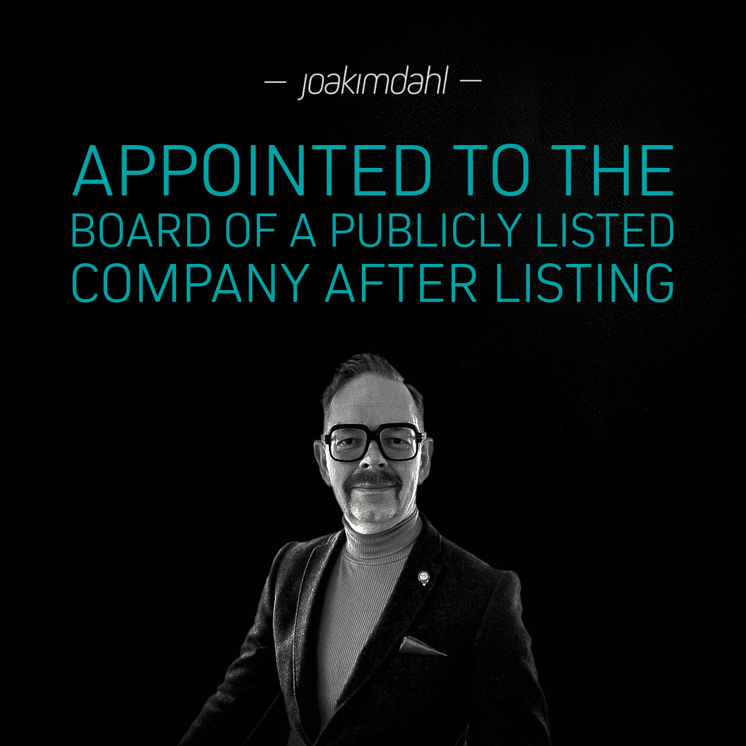 Man in a black suit with glasses, smiling, appointed to the board of a publicly listed company.