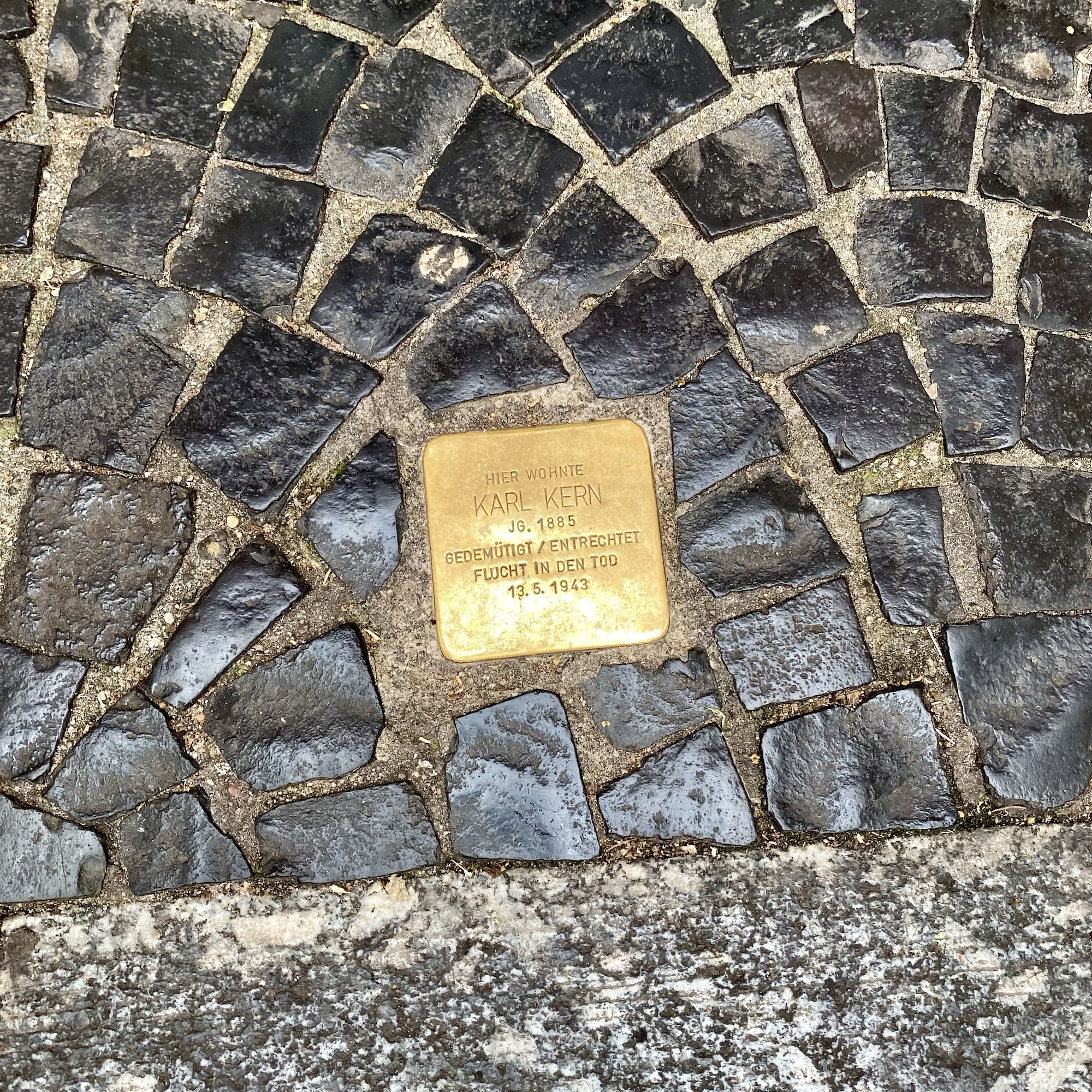 Brass memorial plaque embedded in cobblestone, commemorating Karl Kern, born 1903 and murdered in 1943.