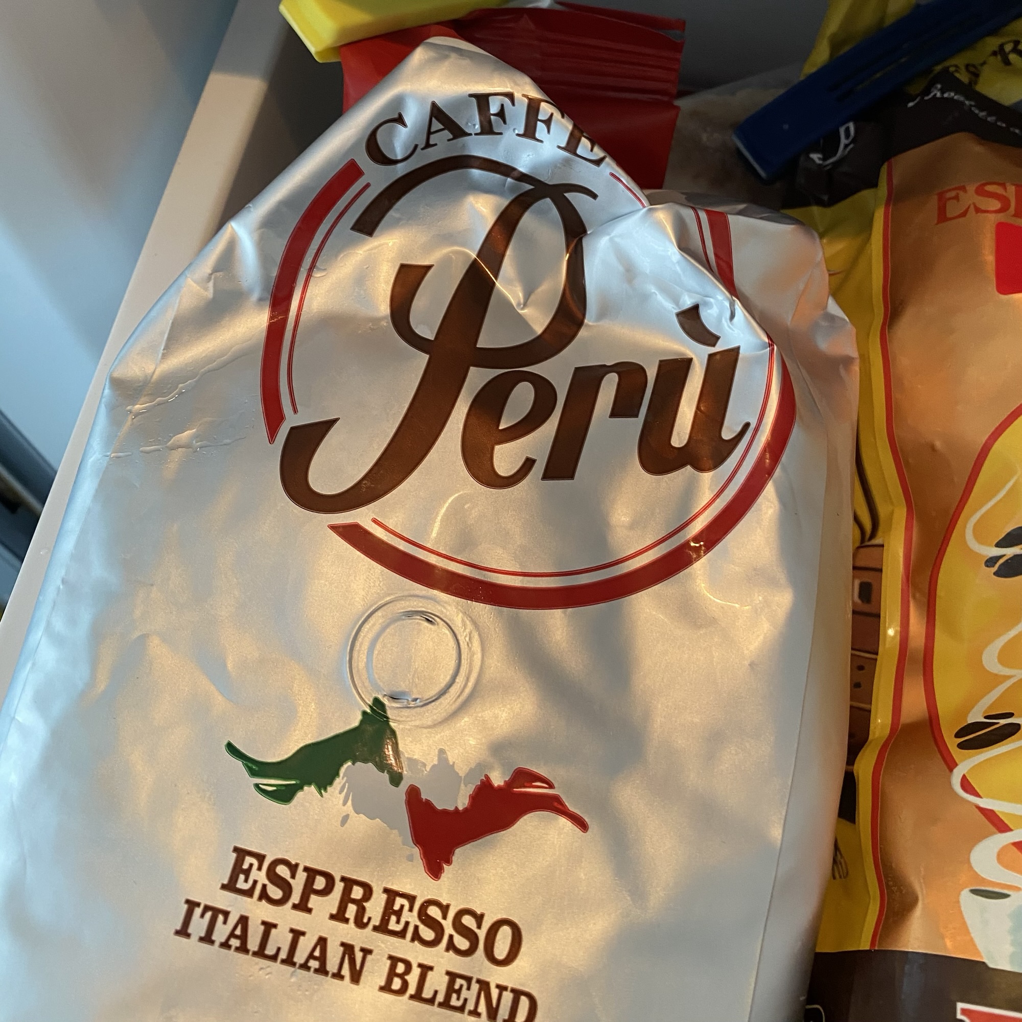 A silver Caffè Perù Espresso Italian Blend bag from Circi roastery sits among other coffee packs, with bold branding and Italian colours visible.
