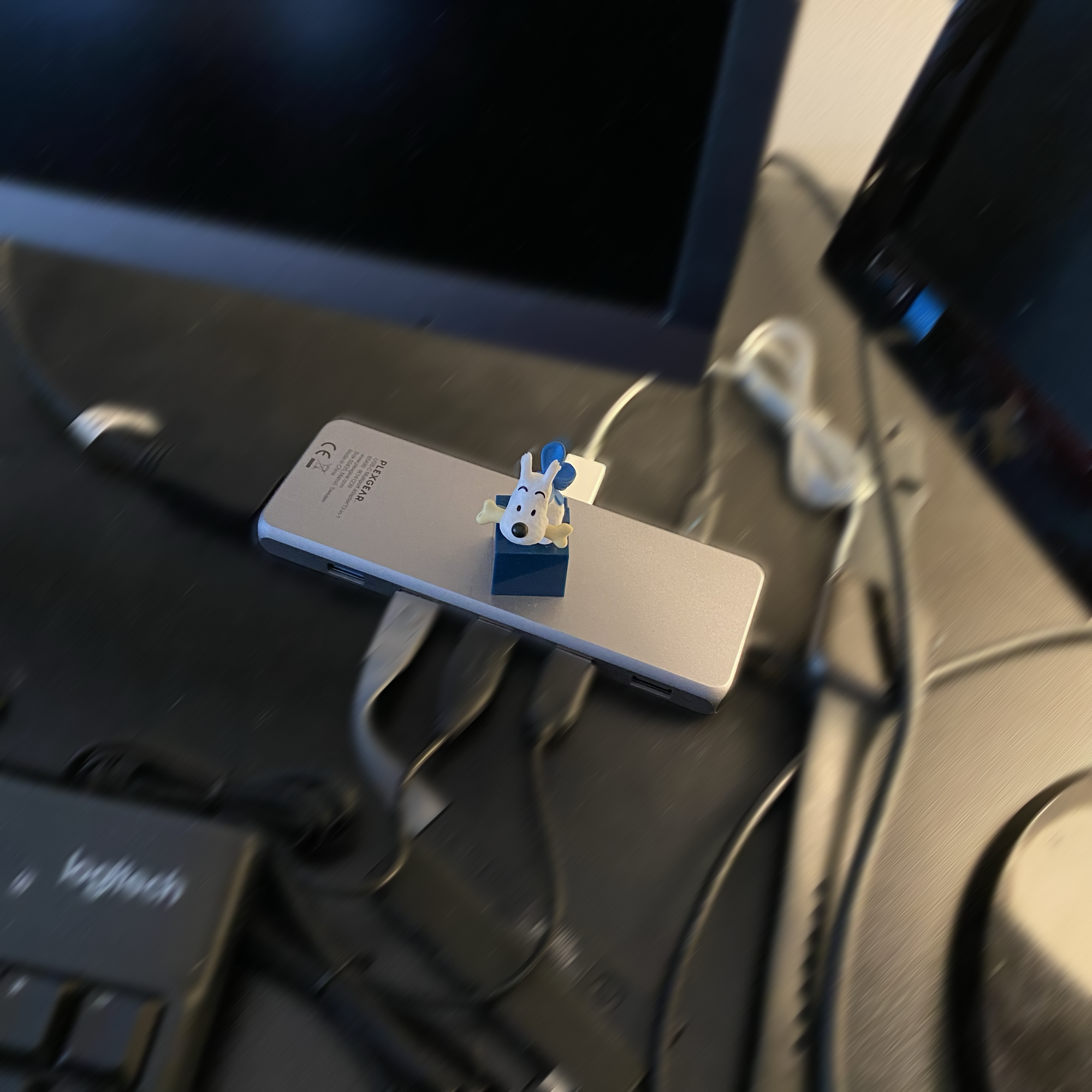 Milou from The Adventures of Tintin in blue and white guarding a workspace phone while annual reports are handled with a split video signal across screens.