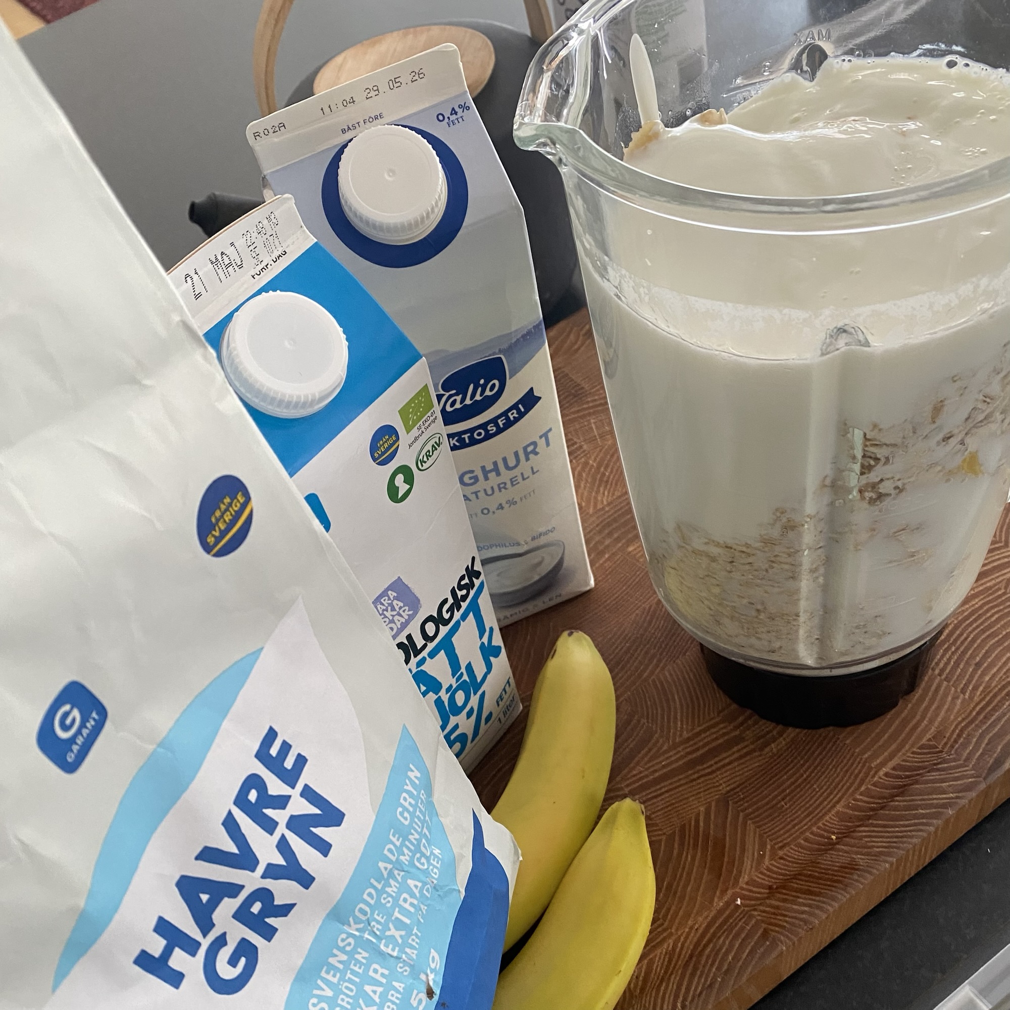 Valio skyr, Arla milk, bananas and oats sit beside a blender of thick breakfast mix with Swedish labels and 0.4% fat text visible.