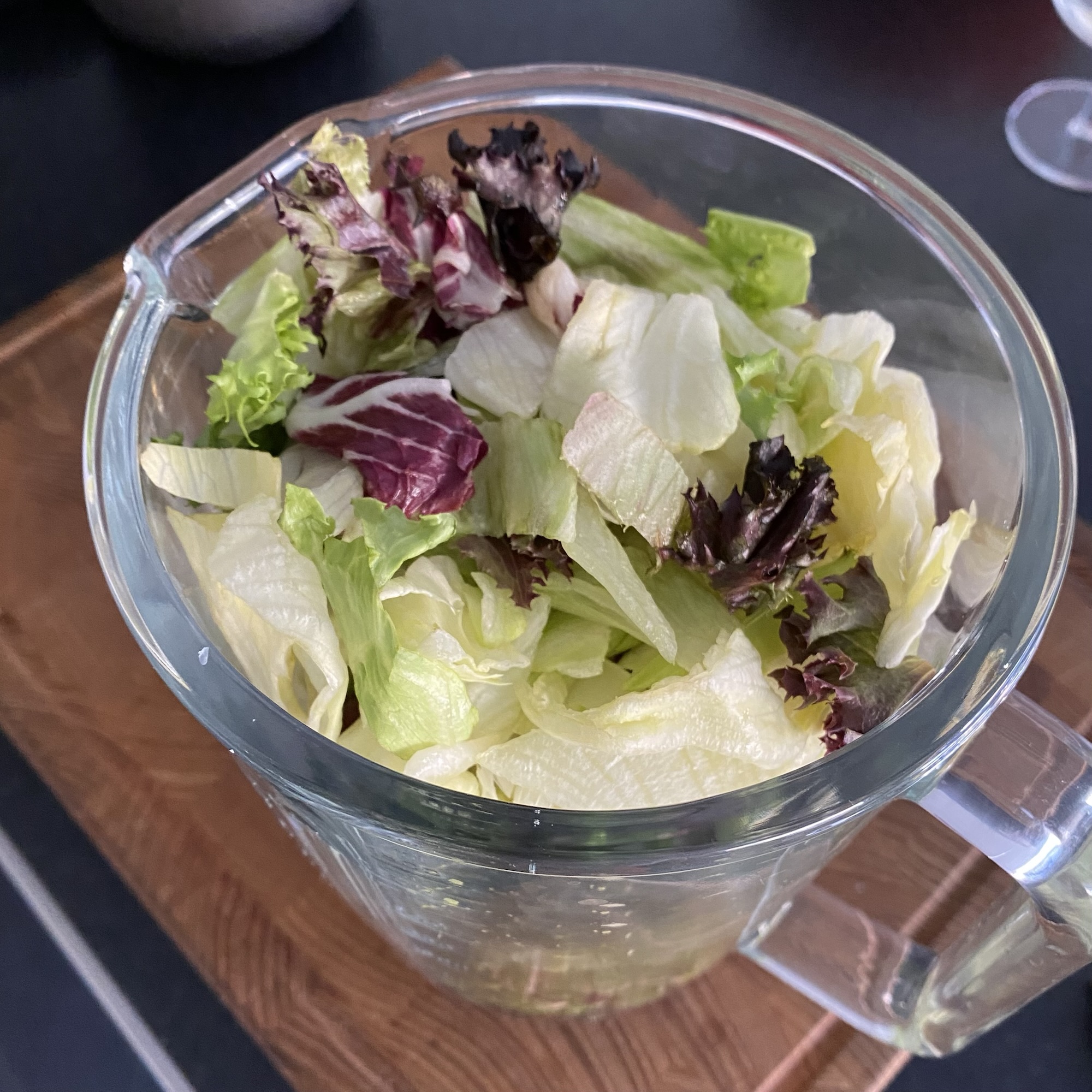 Fresh mixed lettuce leaves in a glass blender jar, ready for a vegetable juice or superfood blend from the superfoods list.