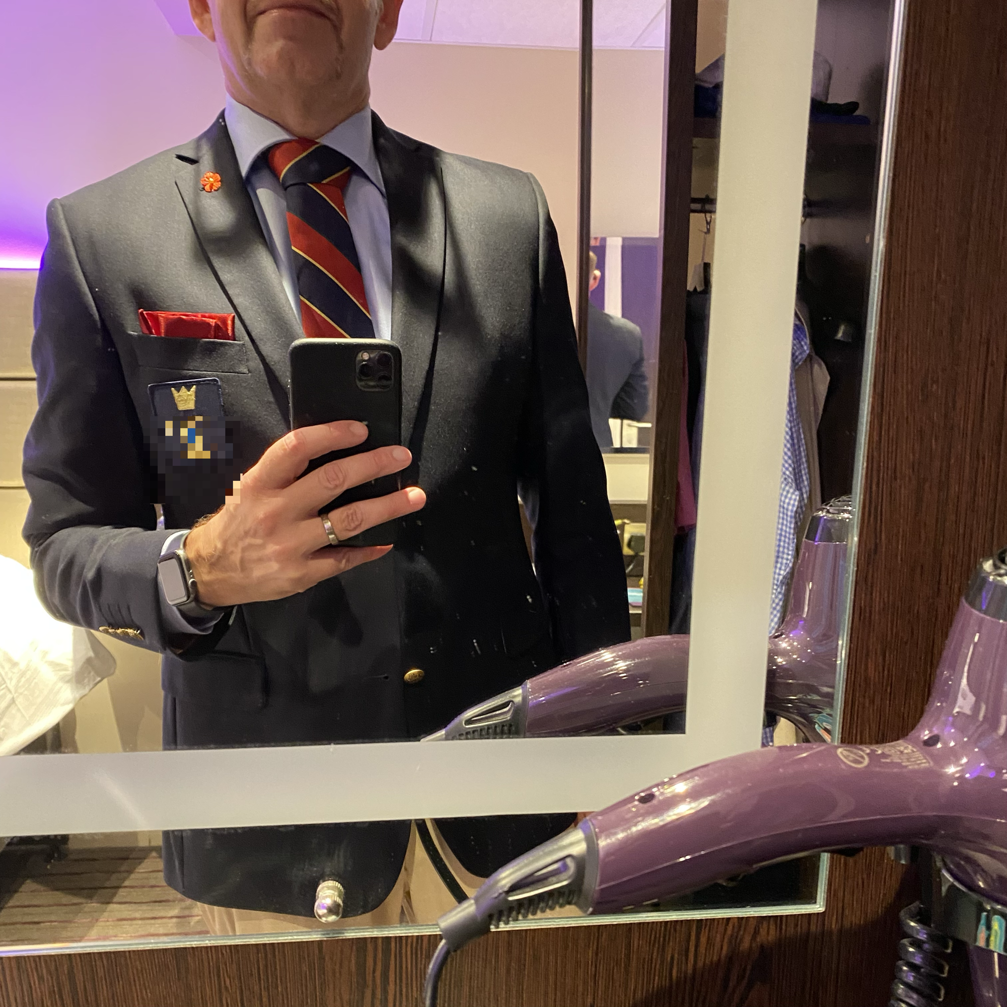 A man in a grey suit and striped tie takes a mirror selfie before leaving a hotel for St James’s Square.