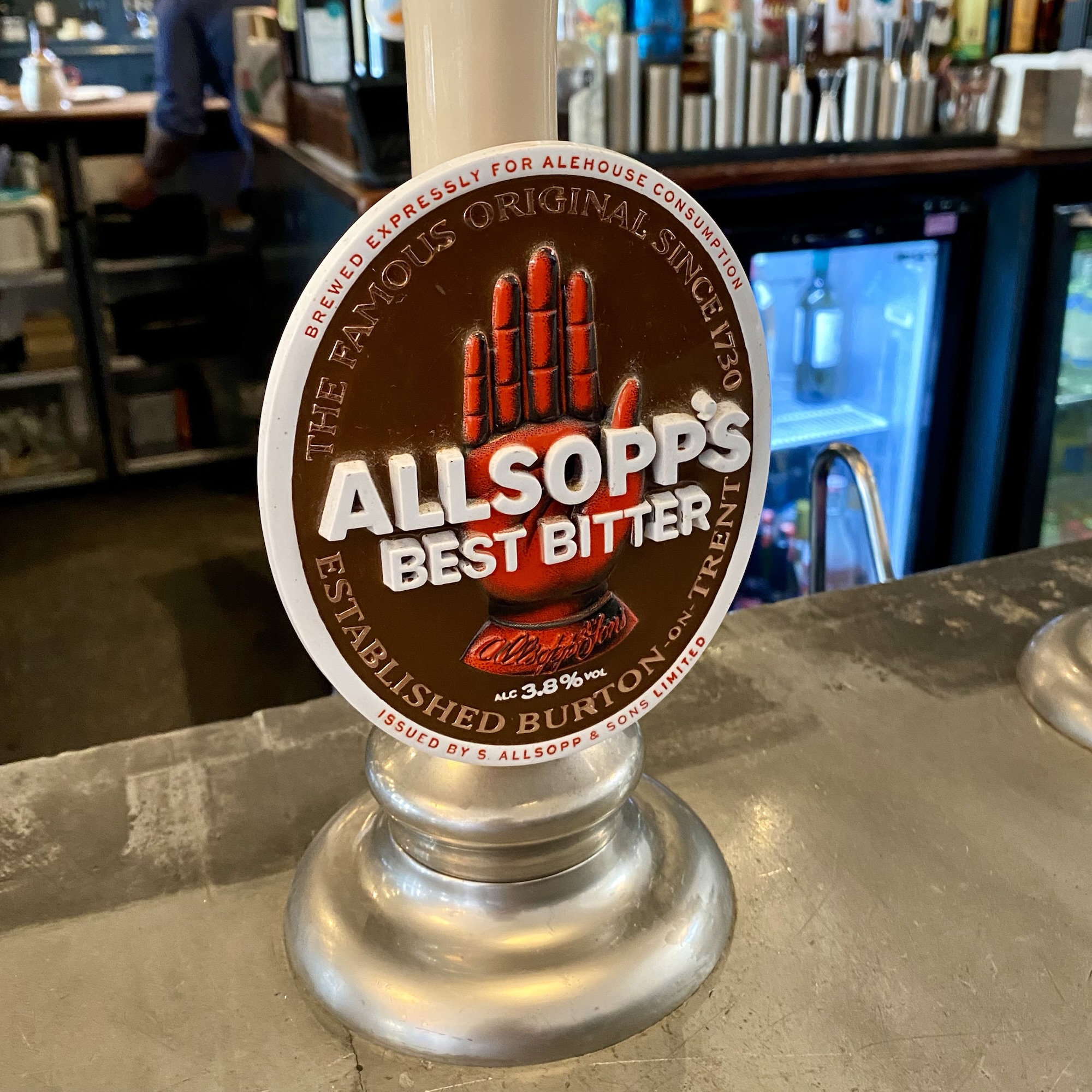 Allsopp’s Best Bitter pump with its red hand emblem and historic Burton brewing references at a Chelsea pub bar
